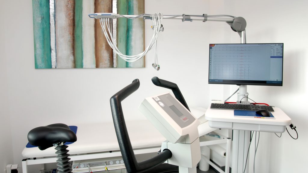 Ein Standfahrrad vor einem EKG-Gerät zur EKG-Messung unter Belastung