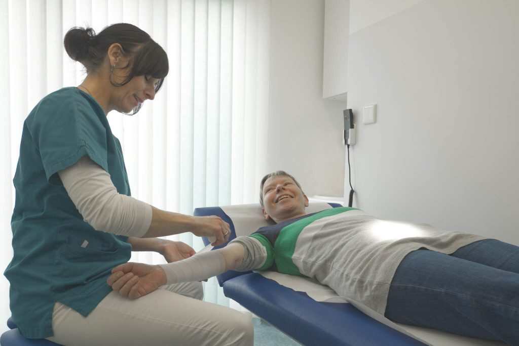 Aufnahme einer Patientin der ein Verband am rechten Arm angelegt wird